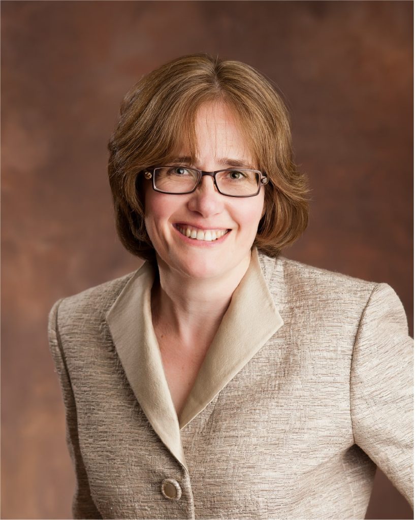 Smiling female CEO in a cream-colored suit