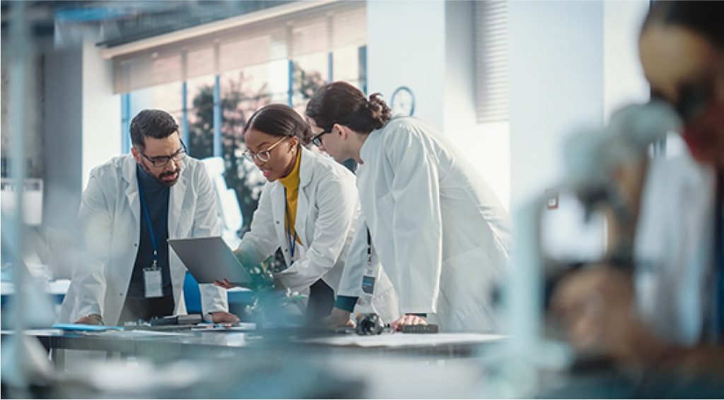 Scientists in white coats discussing the results of their research in a lab