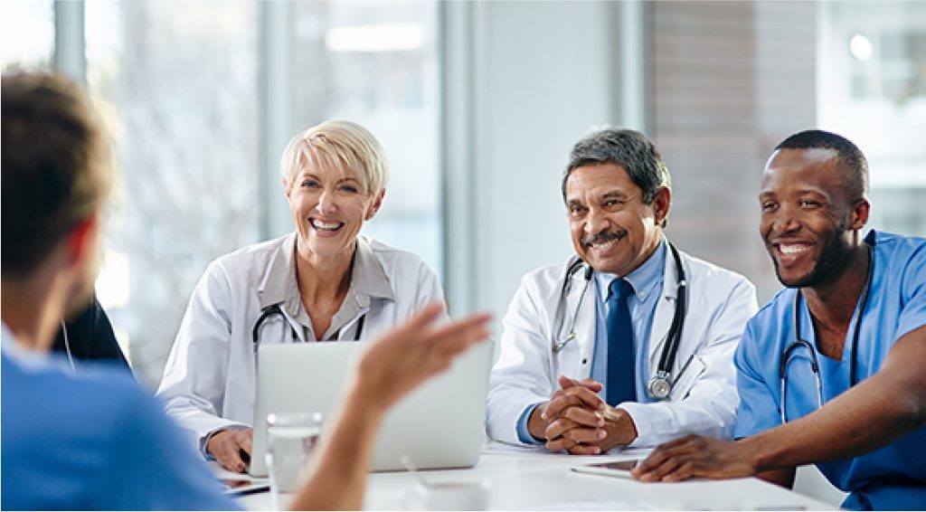 Consultants sitting around a table discussing positive patient results